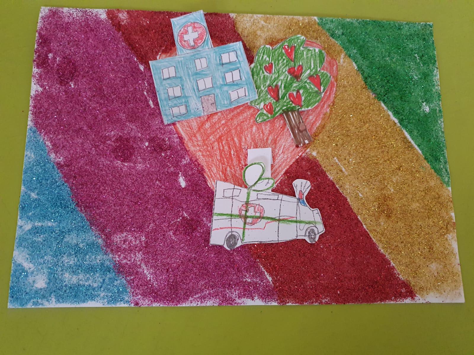 Praca plastyczna wykonana przez dzieco. Przedstawia ambulans, szpital i serce na kolorowym tle.