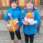 Dwoje dzieci prezentują znalezione koszyczki z prezentami.