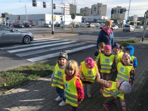 Grupa dzieci idących chodnikiem wraz z panią