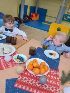 2 chłopców siedzi przy stole i patrzy się na siebie.