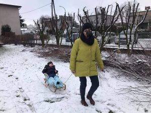 Nauczycielka ciągnie na sankach chłopca.