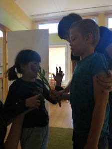 Chłopiec wraz z Panią wręczający dziewczynce tulipana.
