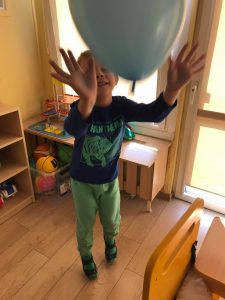 Chłopiec rzuca balon do góry.