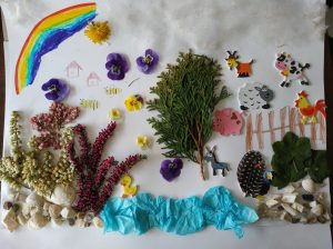 Praca plastyczna: przyklejone na kartkę ususzone rośliny, naklejki różnych zwierząt domowych, narysowana tęcza.