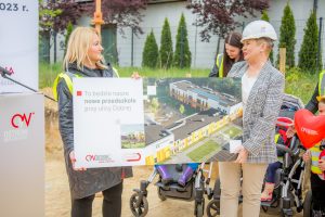 Pani Dyrektor wraz z Pania Prezydent trzymające w rękach makietę, na której widnieje wizualizacja nowego przedszkola.