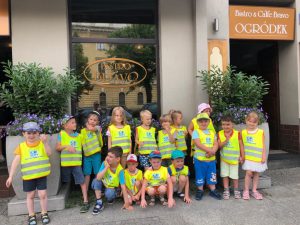 Grupa dzieci pozujących do zdjęcia przed restauracja Bistro Bravo.