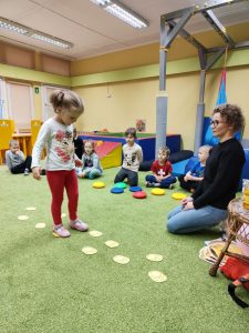 Dziewczynka chodzi po śladach łap misia wyciętych z papieru