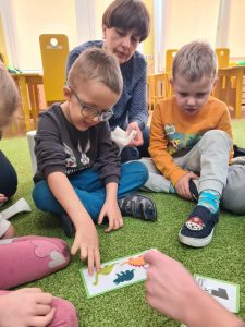 2 chłopców patrzy na karty w dinozaurami