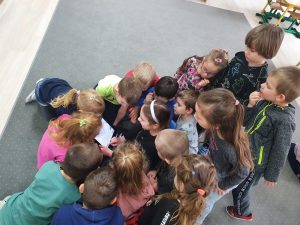 Dzieci na dywanie bawią się tabletem