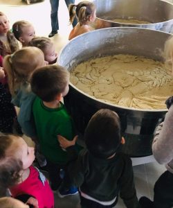 Dzieci ustawione wokół dużej miski z ciastem.