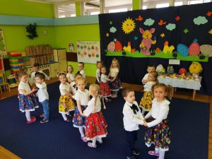 Dzieci tańcza trzymając się za ręce w parach.
