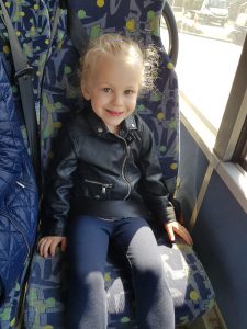 Dziewczynka siedzi w autobusie.