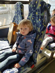 Dziewczynka siedzi w autobusie.