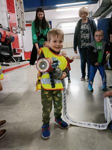 Chłopiec trzyma wąż pożarniczy