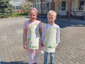 Dziewczynka i chłopiec ubrani w ekologiczne fartuszki wykonane z papieru i sznurka