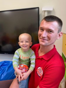 Pan sportowiec trzyma chłopca z piłką.