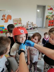Chłopiec zakłada kask ratownika medycznego