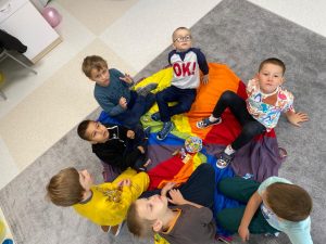 Dzieci siedzą na dywanie