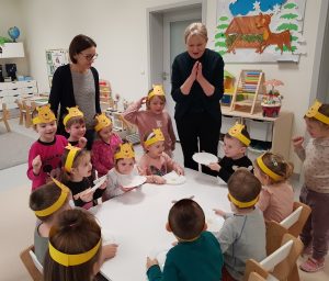 Dzieci siedzą przy stole i jedzą miód