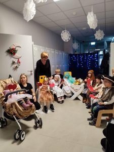 Przebrane Dzieci siedzą na krzesełkach i trzymają w ręce serduszka
