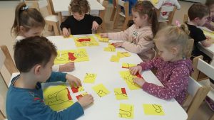 dzieci układają puzzle na stoliku