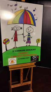 Plakat konkursu piosenki. Na plakacie narysowane dwoje dzieci, które trzymają parasole.