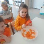 DZIEWCZYNKA OBIERA MARCHEWKĘ