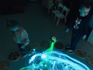 Dziewczynka i chłopiec spacerują po sensorycznej ścieżce.