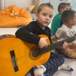 Chłopiec gra na gitarze
