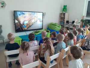 Dzieci oglądają film na tablicy multimedialnej