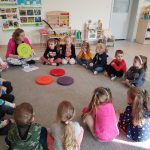 Dzieci z Panią psycholog siedzą w kole na dywanie