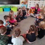 Dzieci z Panią psycholog siedzą w kole na dywanie