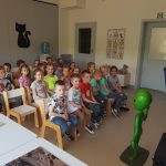 Dzieci słuchające pana astronoma stojącego pogadanki o kosmosie