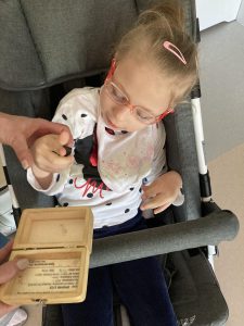 Dziewczynka ogląda i dotyka meteorytu.