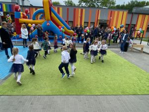 Dzieci w parach tańczą na zielonym dywanie