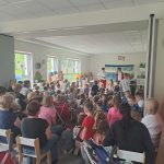 Dzieci oraz panie oglądające teatrzyk. Naprzeciw stoi dwóch mężczyzn występujących w teatrzyku.