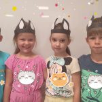 Dwie dziewczynki i dwóch chłopców stoją obok siebie, przytulają się i są uśmiechnięci. Na głowie mają uszy kocie.
