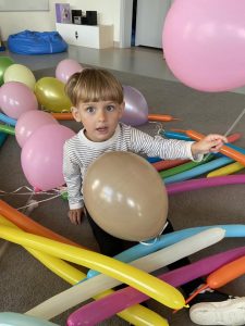 Chłopiec siedzi wśród balonów