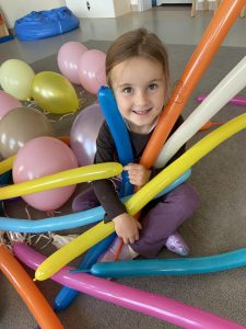 Dziewczynka siedzi wśród balonów