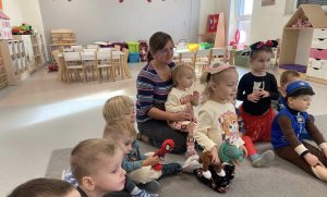 Dzieci słuchają bajki czytanej przez panią bibliotekarkę