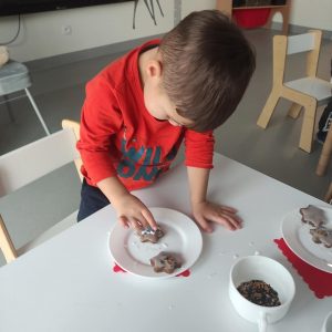 CHŁOPIEC DEKORUJE PIERNIKI