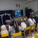 Rodzice oglądają wraz z dziećmi prezentację dotychczasowych działań z pobytu w przedszkolu.