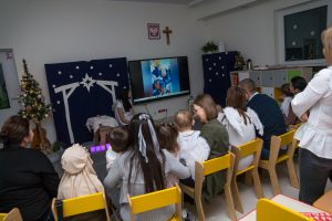 Rodzice oglądają wraz z dziećmi prezentację dotychczasowych działań z pobytu w przedszkolu.