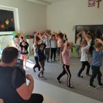 Muzyk gra na instrumencie, a dzieci tańczą