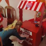 Dziewczynka wrzuca list do poczty Św. Mikołaja.