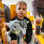 Chłopiec z grupy Wiewiórki siedzi na krzesełku trzyma pluszowego misia w rękach.