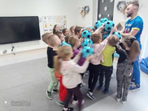 Dzieci bawią się zielonymi piłkami.
