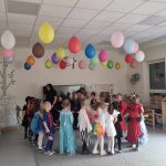 Dzieci przebranych w różne postaci bawią si e na balu karnawałowym.