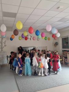 Dzieci przebranych w różne postaci bawią si e na balu karnawałowym.