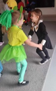 Dzieci przebranych w różne postaci bawią si e na balu karnawałowym.